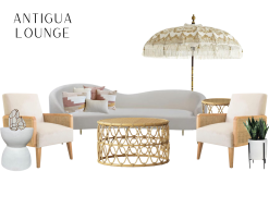 A cream and gold umbrella sitting behind an ivory, curved shaped sofa, with two cream and rattan side chairs on either side of sofa. One rattan, round coffee table and one side table.