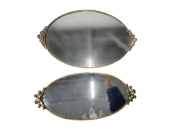 Two oval mirrored serving trays with ornate gold trim.