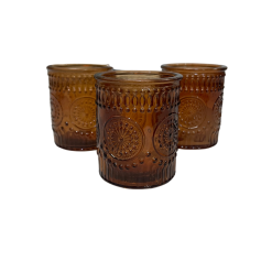Three translucent, deep brown colored glass votive candle holders with an ornate, raised primrose or floral pattern on their surfaces. The votives are cylindrical