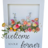 White rectangular box with a cut out for flowers. Bright colored flowers from the box and custom vinyl on the bottom