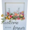 White rectangular box with a cut out for flowers. Bright colored flowers from the box and custom vinyl on the bottom