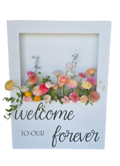 White rectangular box with a cut out for flowers. Bright colored flowers from the box and custom vinyl on the bottom
