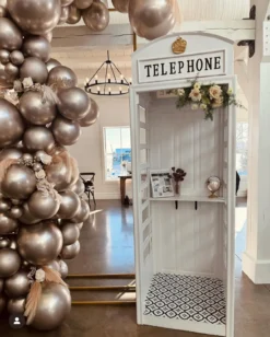 Pierre Phone Booth styled at event with balloon garland and vintage decor