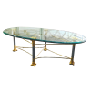 Shagri Coffee Table for rent at Violet Vintage Indianapolis: A Regency-style oval glass coffee table featuring a beveled edge and an ornate mixed-metal base with gold-finished carved capitals, silver pillars, and gold-sculpted feet.