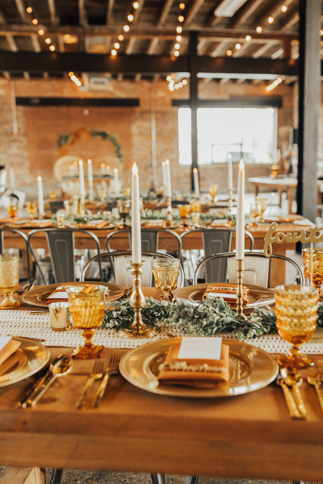 Amber goblets and large brass candlesticks on a fall wedding reception table at INDUSTRY Indianapolis