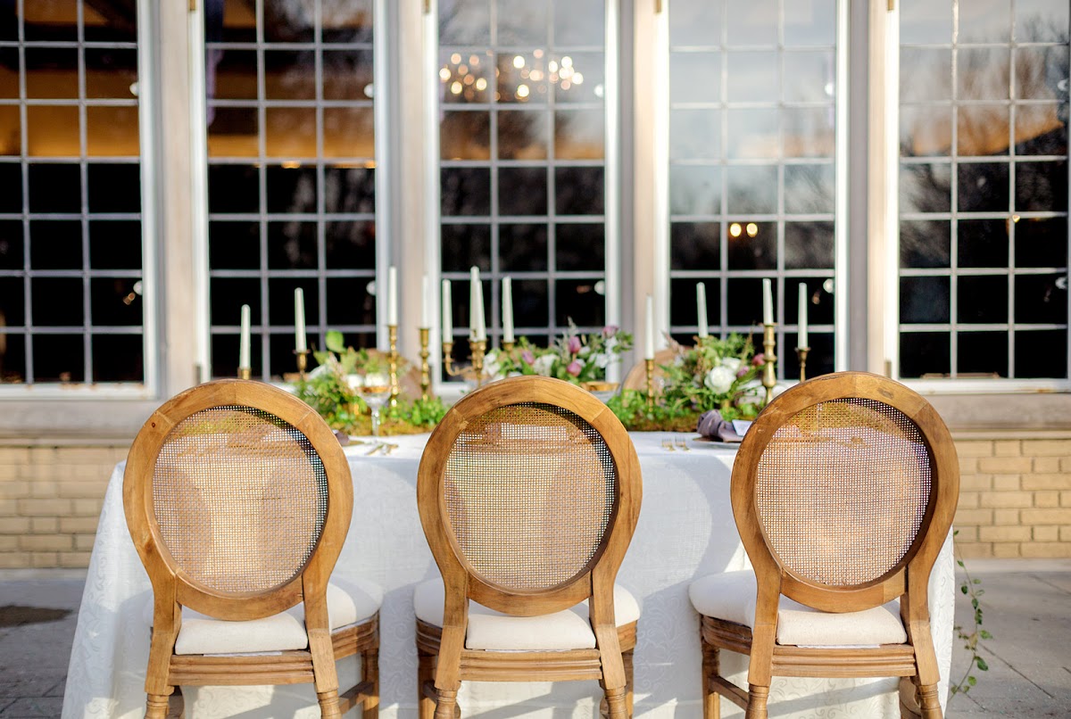 Louis cane back chairs styled around a romantic Laurel Hall wedding table with florals and brass candlesticks