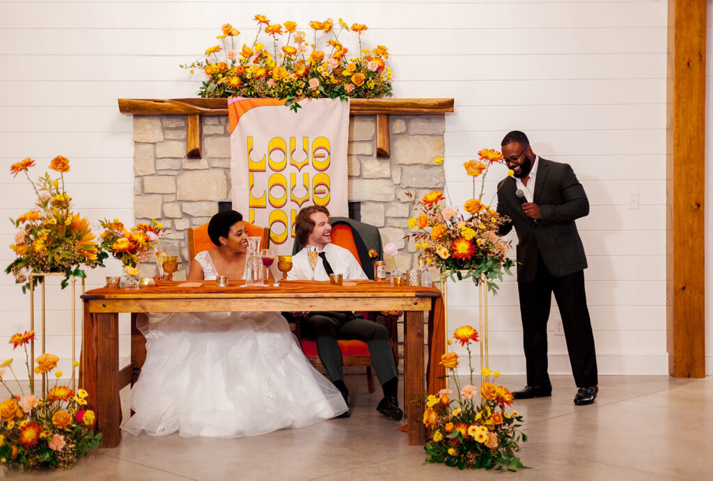 Lauren and Cole at their colorful sweetheart table with Clement Chairs at The Wilds near Bloomington, Indiana
