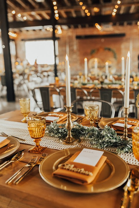 Amber goblets and Large Brass Candlesticks on a long fall wedding reception table at INDUSTRY in Indianapolis