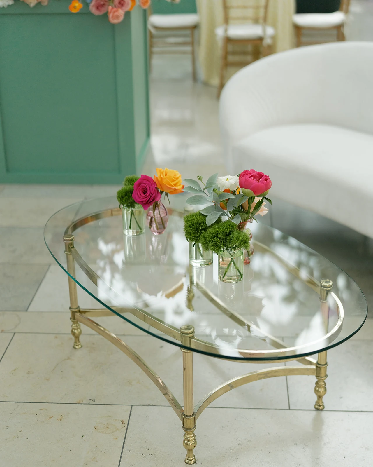 Gia glass coffee table with small colorful florals beside an Avalon Sofa at the Indianapolis Artsgarden